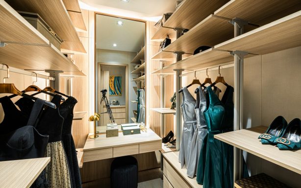 Dressing room avec des vêtements suspendus, miroir et lumière douce.